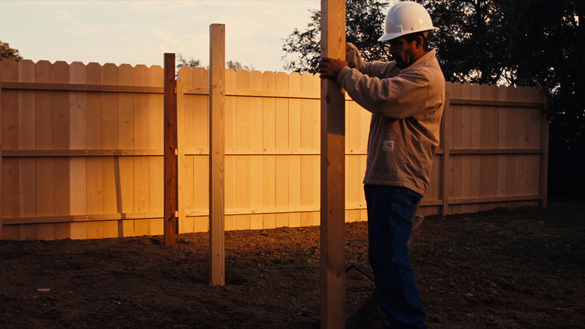 Installing a new wood fence at golden hour
